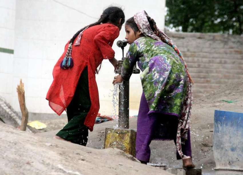 لاہور: دو بچیاں شدید گرمی میں پیاس بجھانے کے لیے ہینڈ پمپ ..