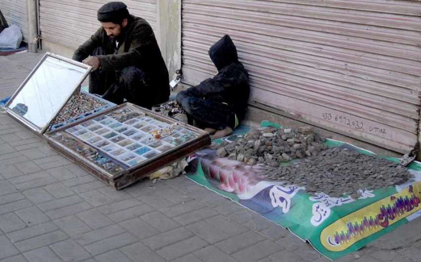 راولپنڈی: ایک شخص فٹ پاتھ پر انگوٹھیاں سجائے فروخت کے لیے ..