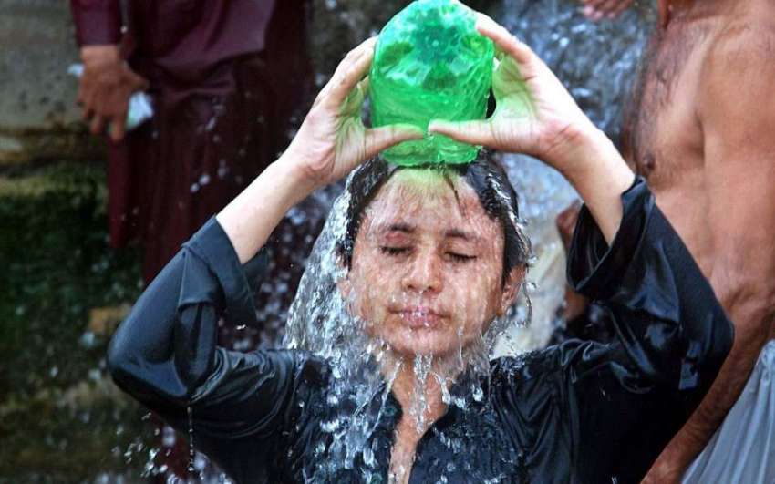 راولپنڈی: ایک نوجوان گرمی کی شدت کم کرنے کے لیے نہا رہا ہے۔