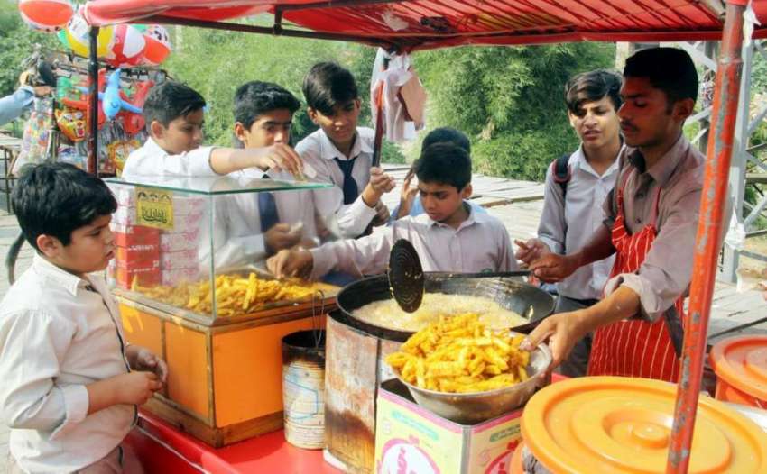 لاہور: بچے سکول سے چھٹی کے بعد ایک ریڑھی سے چپس خرید رہے ہیں۔