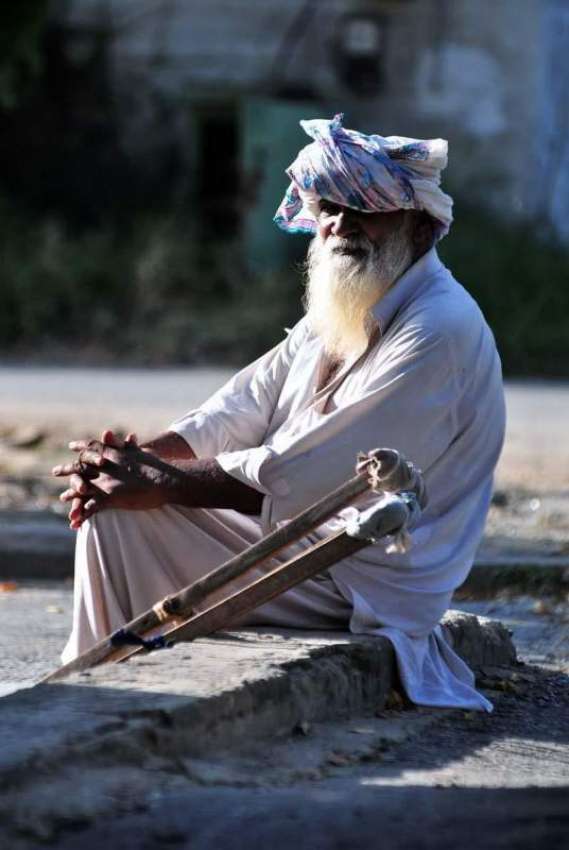 اسلام آباد: ایک معذور شخص سڑک کنارے بیٹھا ہے۔