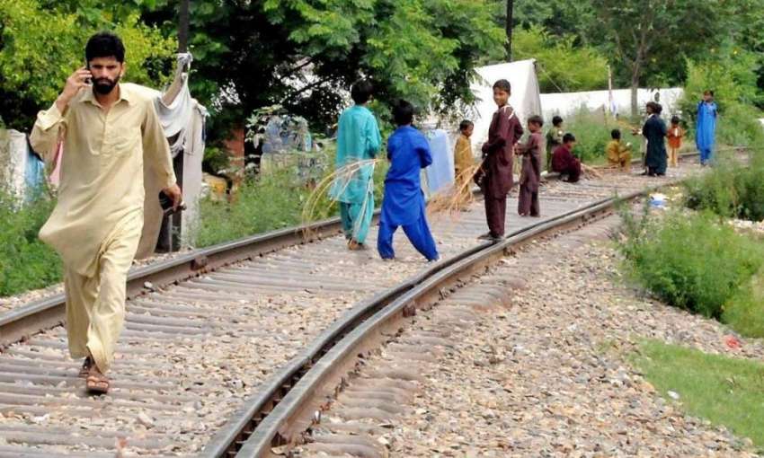 راولپنڈی: بچے ریلوے ٹریک پر کھیل رہے ہیں جبکہ ایک شہری موبائل ..