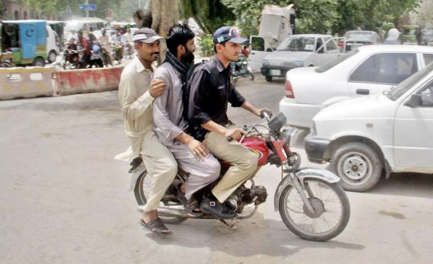 لاہور: ایک پولیس اہلکار ٹریفک قوانین کی خلاف ورزی کرتے ہوئے ..