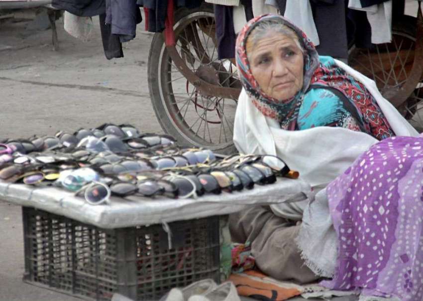 لاہور: ایک بزرگ خاتون داتا دربار کے قریب زمین پر بیٹھی عینکیں ..