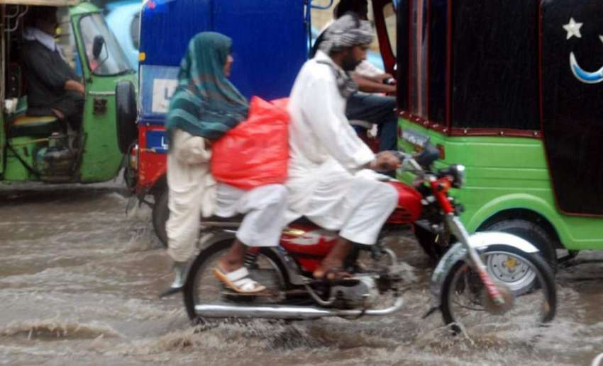 لاہور : شہر میں ہونے والی موسلا دھار بارش کے بعد موٹر سائیکل ..