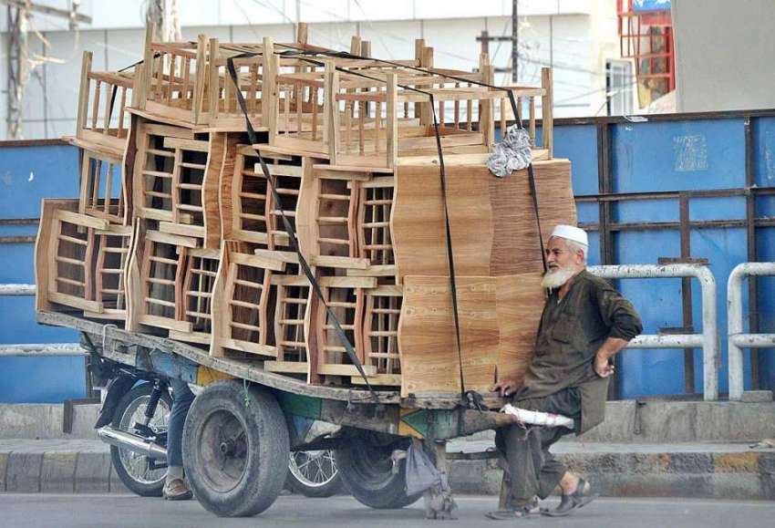 راولپنڈی: ایک معمر محنت کش سامان سے بھری ہتھ ریڑھی کھینچتے ..