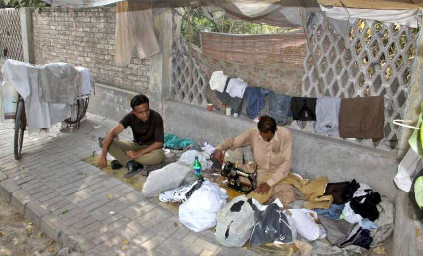 لاہور: چائنہ چوک کے قریب ایک درزی نے فٹ پاتھ پر دکان سجا رکھی ..