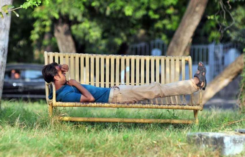 اسلام آباد: مقامی پارک میں ایک نوجوان بینچ پر آرام کر رہا ..