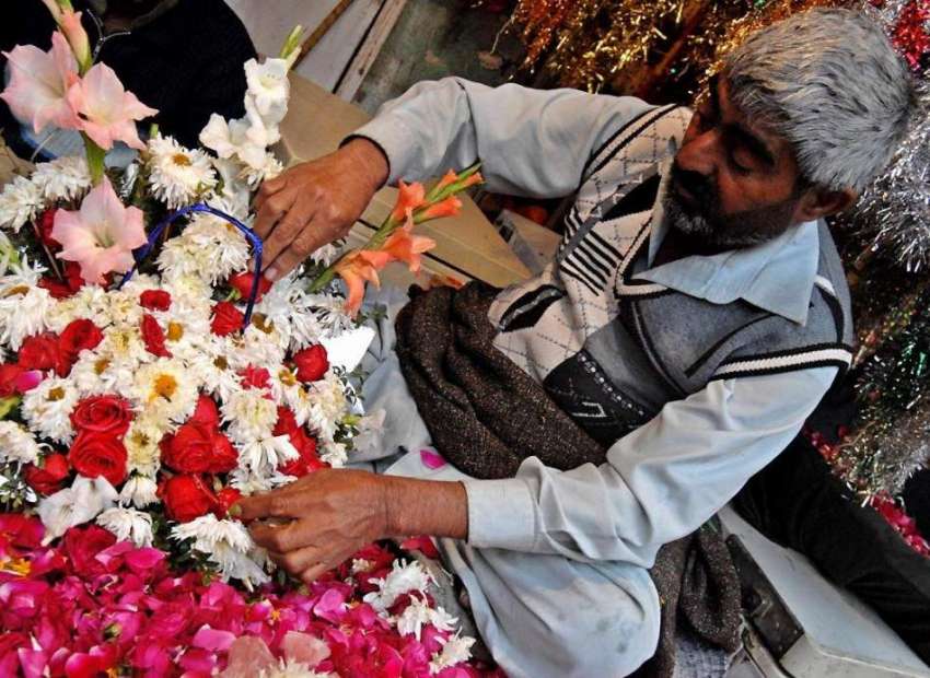 راولپنڈی: کرسمس کی تیاریوں میں مصروف ایک شخص پھولوں کے بوکے ..