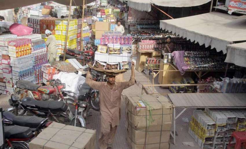 لاہور: مستی گیٹ بازار میں محنت کش بھاری سامان اپنے سروں پر ..
