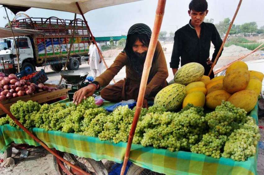 راولپنڈی: ریڑھی بان فروخت کے لیے انگور سجا رہا ہے۔