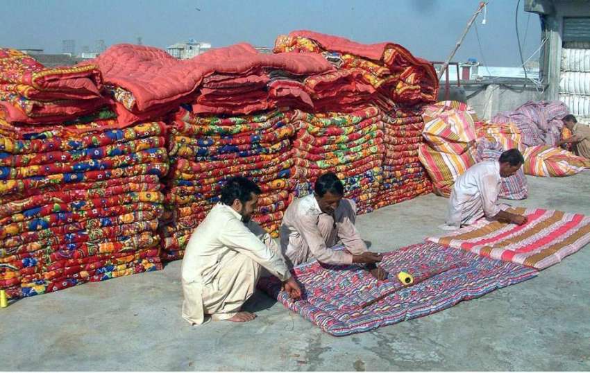 راولپنڈی: مزدور رضائیاں سلائی کررہے ہیں۔