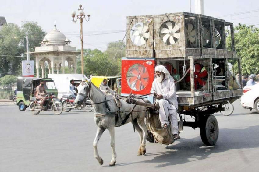 لاہور: ایک محنت کش ریڑھے پر ائیر کولر رکھے مال روڈ سے گزر ..