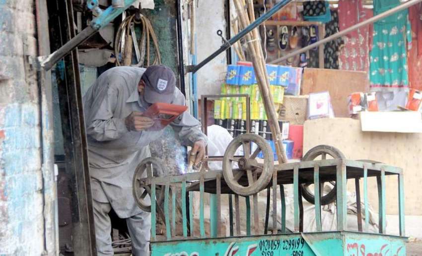 لاہور: ایک ویلڈر ریڑھی کی مرمت میں مصروف ہے۔