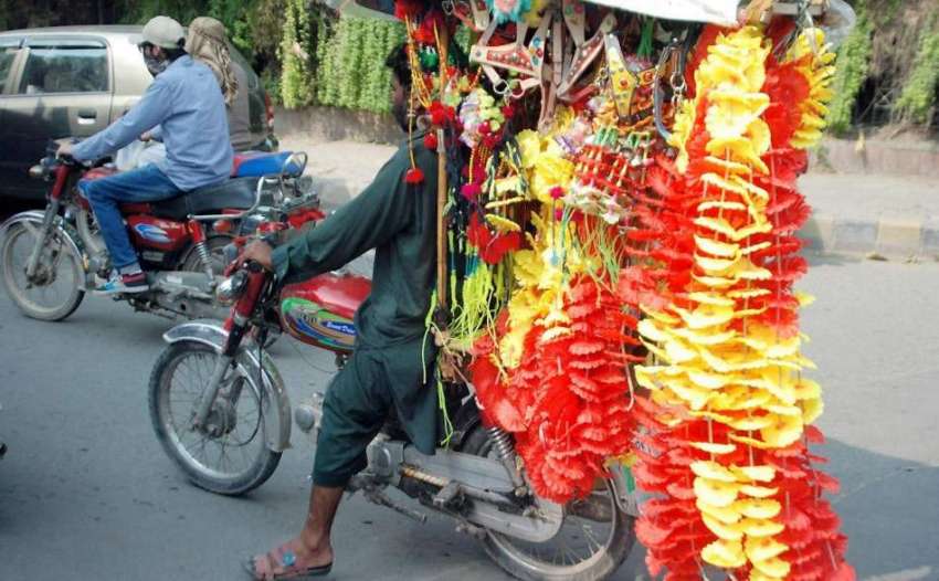 لاہور: ایک شخص موٹر سائیکل پر قربانی کے جانوروں کی سجاوٹ ..