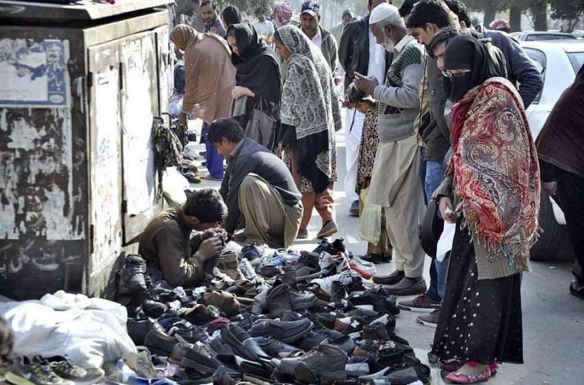 اسلام آباد: سڑک کنارے لگے سٹال سے شہری جوتے پسند کر رہے ہیں۔