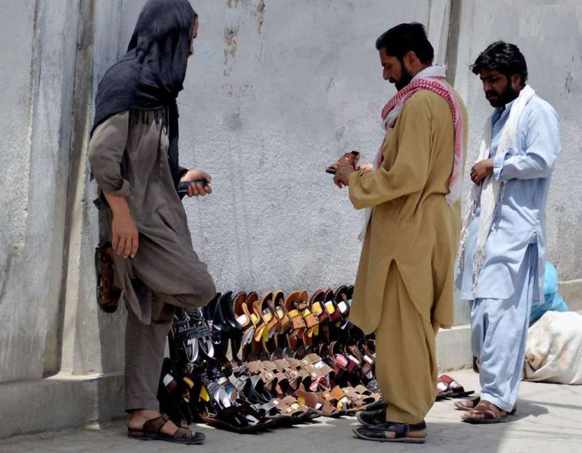 کوئٹہ: جناح روڈ پر ایک شخص ہاتھ سے بنے ہوئے جوتے فروخت کر ..