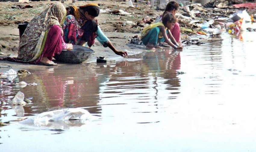 لاہور: خانہ بدوش خواتین دریائے راوی کنارے کپڑے دھو رہی ہیں۔