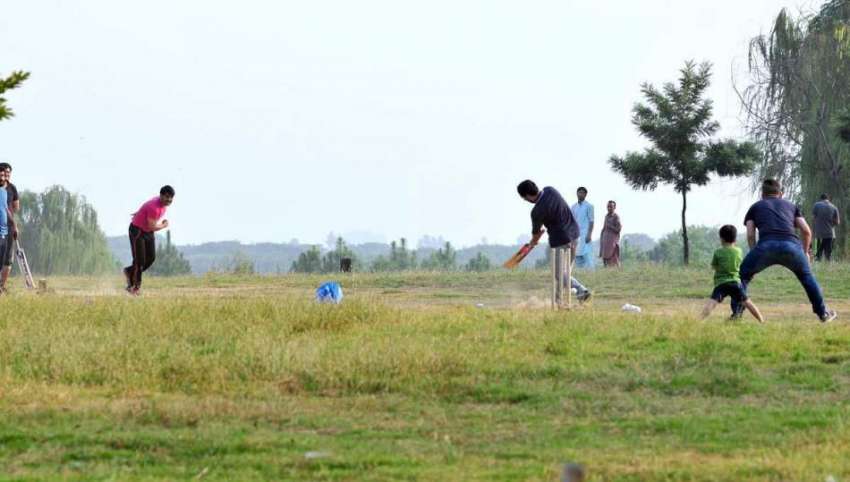 اسلام آباد: نوجوان سڑک کنارے پارک میں کرکٹ کھیل رہے ہیں۔