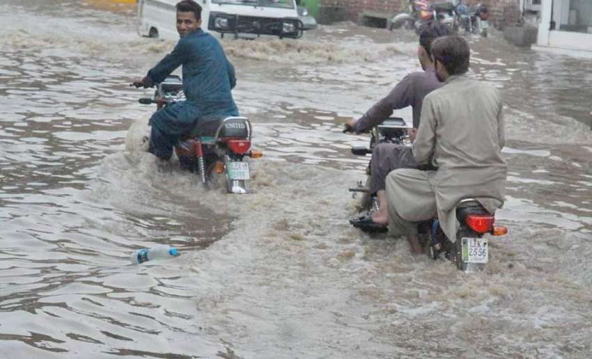 لاہور: شہر میں ہونے والی موسلا دھار بارش کے بعد ایک موٹرس ..