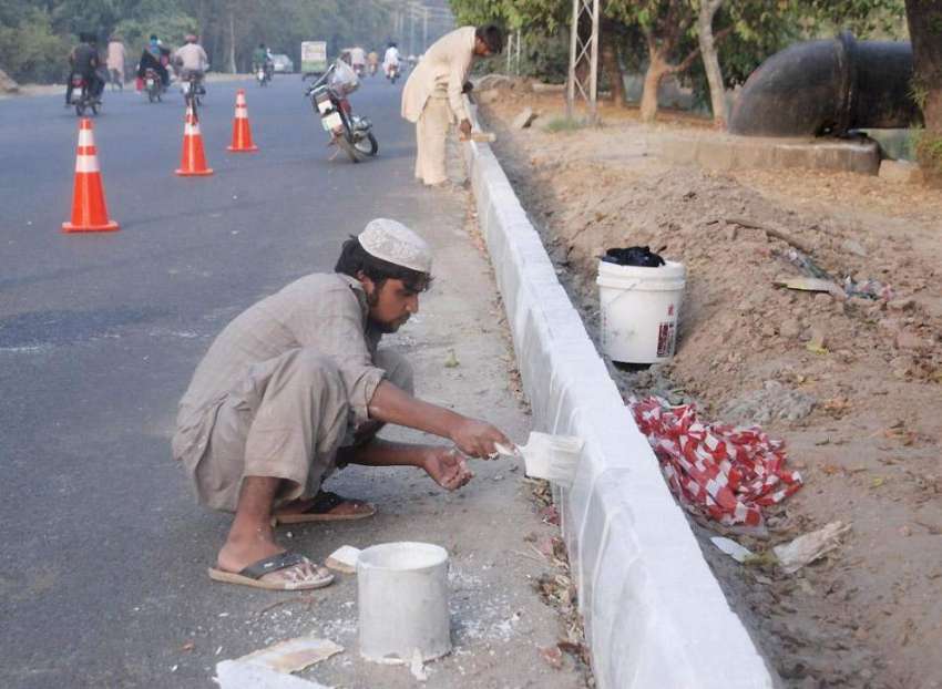 لاہور: محنت کش کینال روڈ پر گریم بیلٹ کی دیوار کو پینٹ کر ..