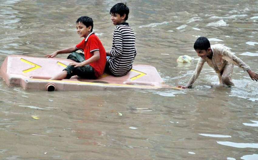لاہور: بچوں نے موسلا دھار بارش کے بعد جمع ہونے والے پانی ..