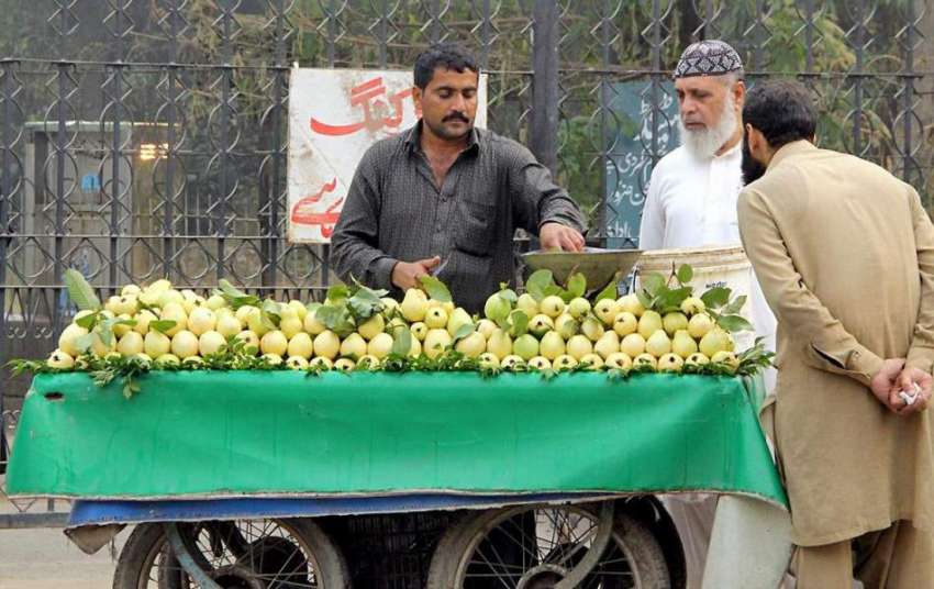 لاہور: شہری ریڑھی بان سے امرود خرید رہا ہے۔