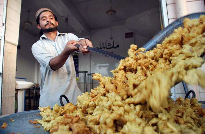 پشاور: دکاندار افطاری کے لیے پکوڑے اور سموسے فرائی کر رہا ..