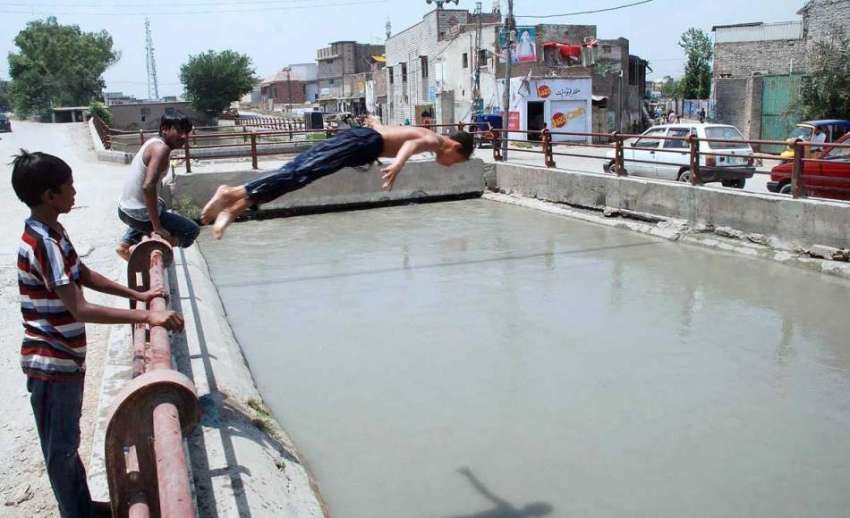 پشاور: نوجوان گرمی کی شدت سے بچنے کے لیے نہر میں نہا رہے ہیں۔