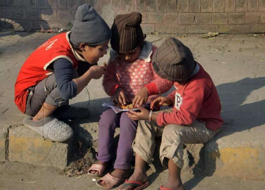 لاہور: کمسن بہن بھائی فٹ پاتھ پر بیٹھے سموسے کھا رہے ہیں۔