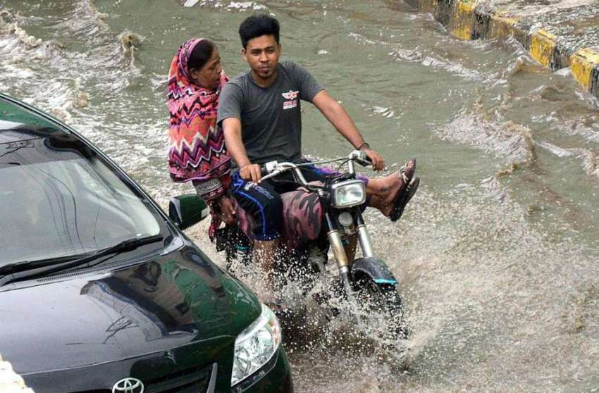 کراچی: موٹر سائیکل سوار بارش کے پانی سے گزر رہا ہے۔