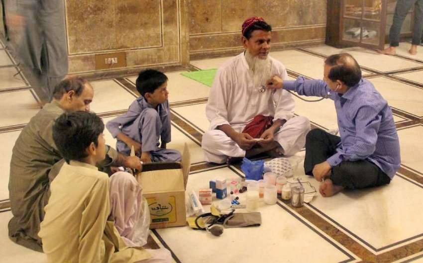 لاہور:بادشاہی مسجد میں لگائے گئے عارضی کیمپ میں ایک شہری ..