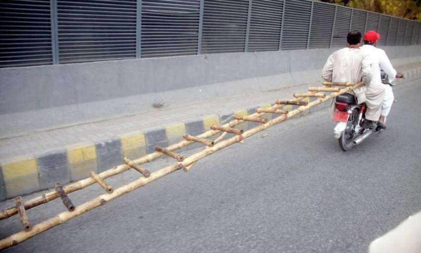 لاہور: شہری موٹر سائیکل پر لکڑی کی سیڑھی لیجا رہے ہیں۔