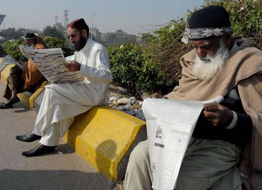 راولپنڈی: فیض آباد میں دھرنے کے شرکاء اخبار پڑھ رہے ہیں۔
