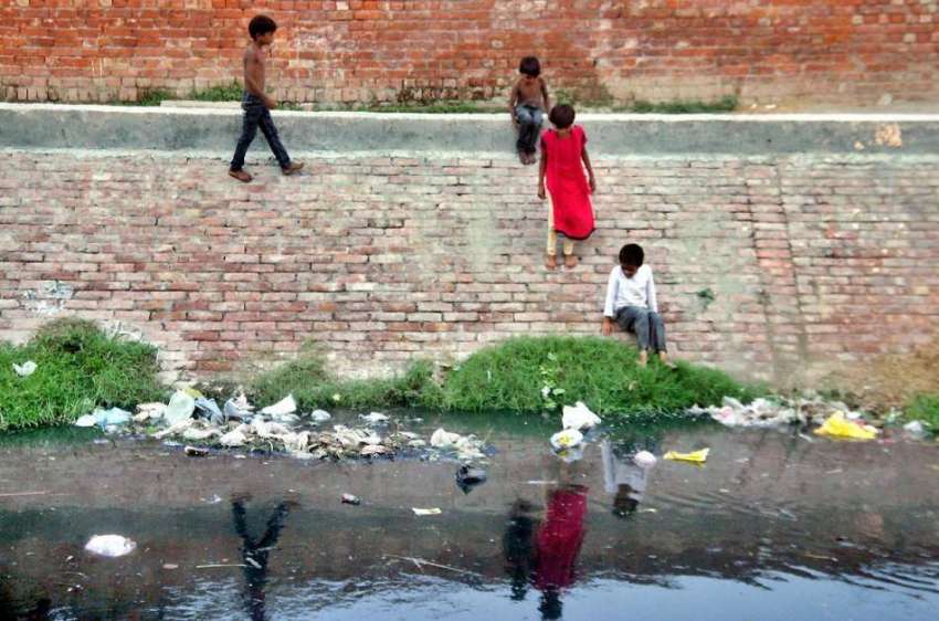 لاہور: بچے روہی نالے کے گرد دیوار پر کھڑے ہیں جو کسی حادثے ..