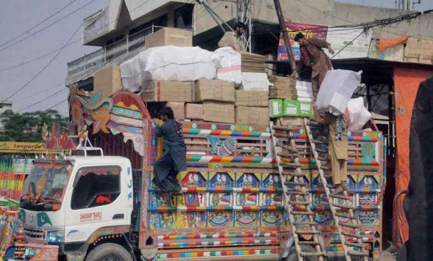لاہور: سرکلر روڈ پر مزدور ٹرک پر سامان لوڈ کررہے ہیں۔