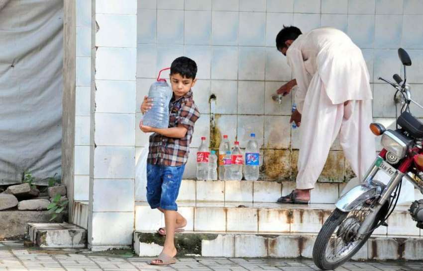 اسلام آباد: ایک نوجوان بچے کے ہمراہ واٹر فلٹریشن پلانٹ سے ..