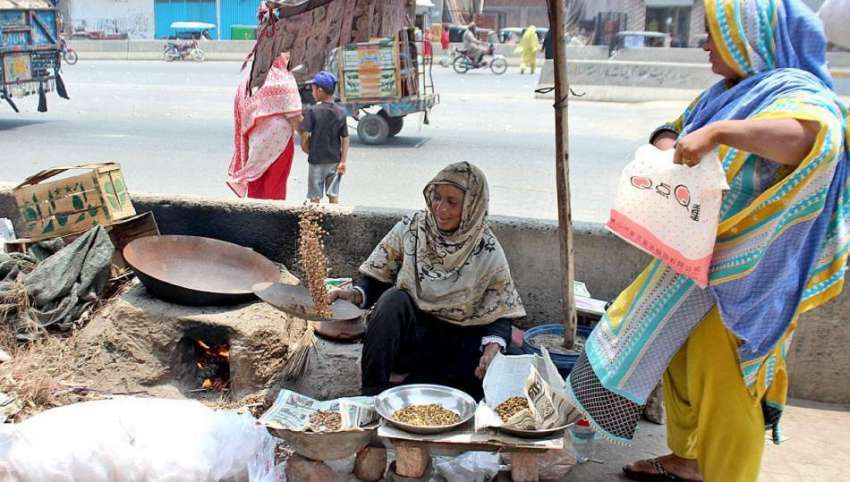 لاہور: ایک معمر خاتون بھٹی پر چنے بھون رہی ہے۔