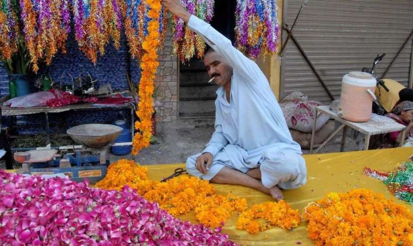 راولپنڈی: ایک دکاندار اپنے سٹال پر عید کے لیے پھولوں کے ہار ..