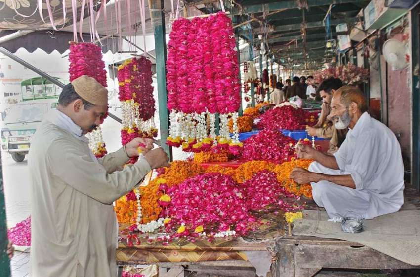 لاہور: دکاندار فروخت کے لیے پھول سجا رہا ہے۔