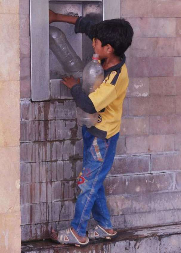 لاہور: ایک بچہ پینے کے لیے پانی بھر رہا ہے۔