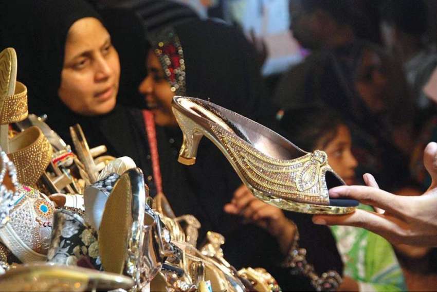 حیدر آباد: خاتون ایک سٹال سے جوتے پسند کررہی ہے۔