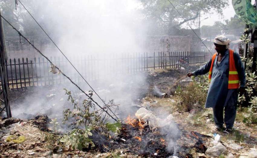 لاہور: مغلپورہ ریلوے لائنوں کے قریب ایک خاکروب کوڑے کو آگ ..