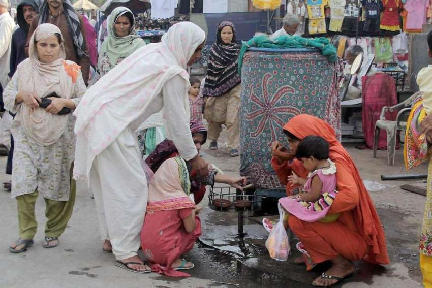 لاہور: خواتین پیر مکی بازار میں لگے کولر سے پانی پی رہی ہیں۔