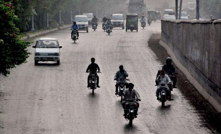 لاہور: مغلپورہ میں ہونے والی بارش کے دوران ٹریفک رواں دواں ..