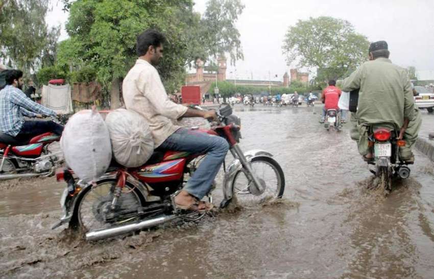 لاہور: شہر میں ہونے والی موسلا دھار بارش کے بعد موٹر سائیکل ..
