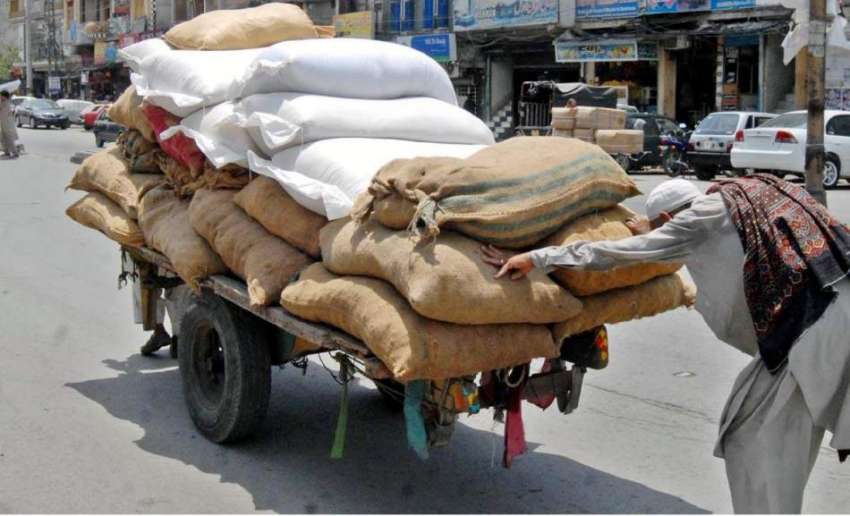 راولپنڈی: ایک محنت کش سامان سے لدے ریڑھے کو دھکا لگا رہا ..