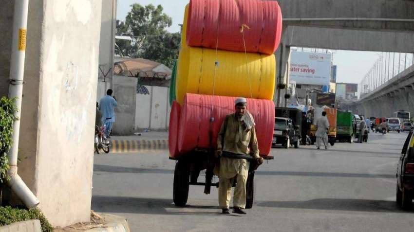 راولپنڈی: ایک مزدور ریڑھے پر کارپٹ فوم لادھے مری روڈ سے گزر ..