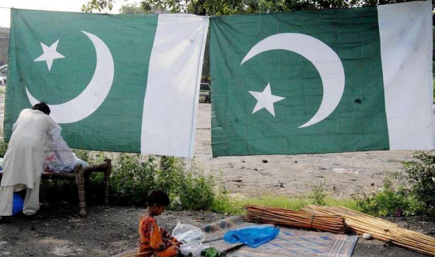 راولپنڈی: 14اگست کے حوالے سے ایک محنت کش نے روڈ کنارے قومی ..
