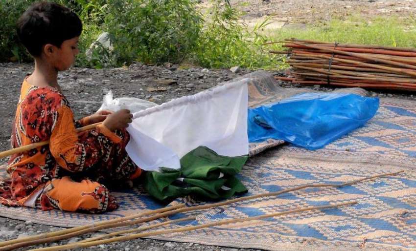 راولپنڈی: 14اگست کے حوالے سے ایک بچی قومی پرچم لگا رہی ہے۔